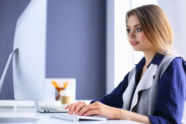 Młoda, pewna siebie bizneswoman pracująca w biurze i pisząca na maszynie z laptopem — Zdjęcie stockowe