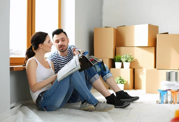 Portret vrolijk glimlachend jong stel schilderen interieur muur van nieuw huis. Jong stel — Stockfoto