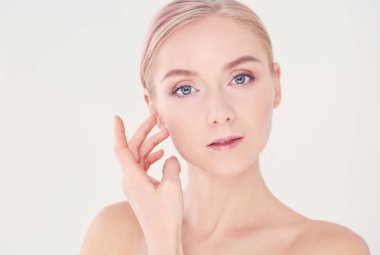 güzel genç kız temiz bir cilt bir el ile bir yanak dokunur.