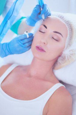 Kaşlar için kalıcı makyaj. Güzellik salonunda kalın kaşlı güzel bir kadın..