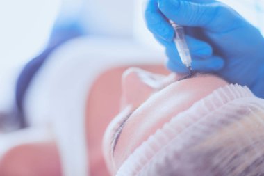 Kaşlar için kalıcı makyaj. Güzellik salonunda kalın kaşlı güzel bir kadın..