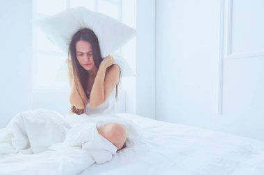 Onun baş ve kulaklar yastık ile kapsayan genç Kafkas kadın.