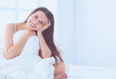 Güzel bir kadın yatağında uzanıyor..