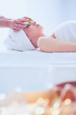 Masaj masasında uzanmış gözleri kapalı rahatlayan genç bir kadın. - Kadın. Spa salonu