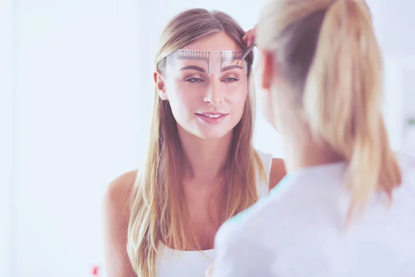 Permanentes Make-up für Augenbrauen. Nahaufnahme einer schönen Frau mit dicken Brauen im Schönheitssalon. — Stockfoto