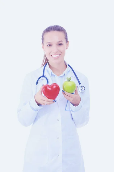 Güzel gülümseyen kadın doktor kırmızı kalp ve yeşil elma tutuyor. Kadın doktor — Stok fotoğraf