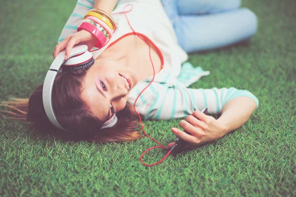 Mooie jonge vrouw die selfie maakt door haar telefoon terwijl ze in groen gras ligt. mooie jonge vrouw maken selfie — Stockfoto