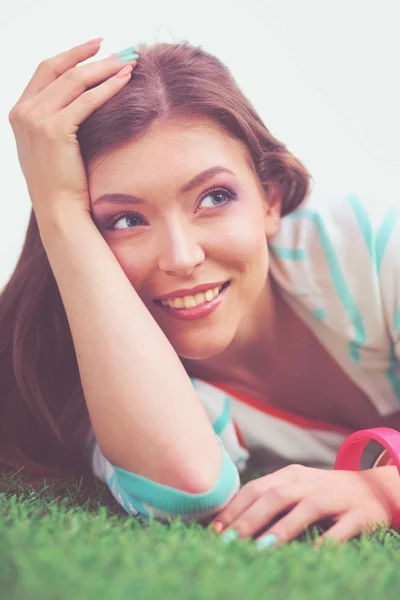 Vacker ung kvinna ligger på det gröna gräset — Stockfoto