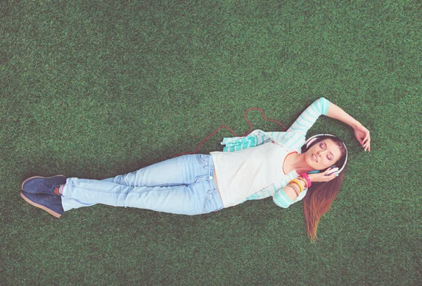 Piękna młoda kobieta leżąca na zielonej trawie — Zdjęcie stockowe
