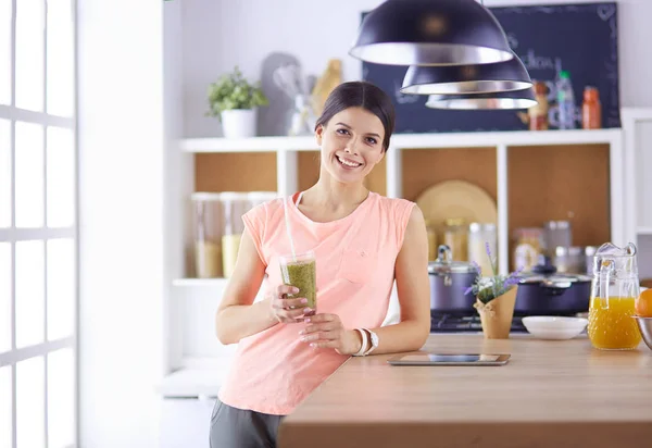 Όμορφη νεαρή γυναίκα χρησιμοποιώντας ένα ψηφιακό tablet στην κουζίνα. — Φωτογραφία Αρχείου