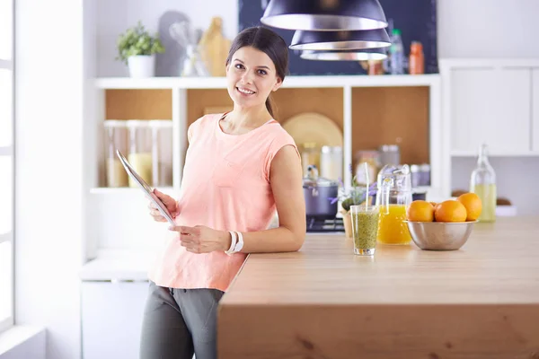 Красивая молодая женщина с помощью цифрового стола на кухне. — стоковое фото