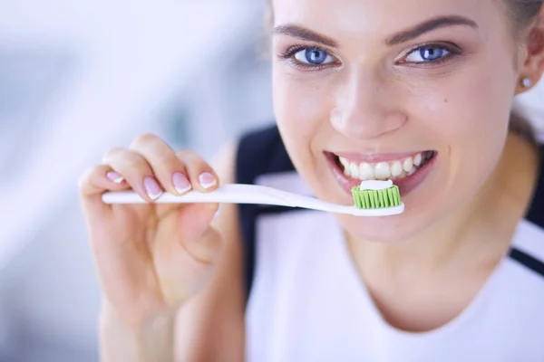Junges hübsches Mädchen pflegt Mundhygiene mit Zahnbürste. — Stockfoto