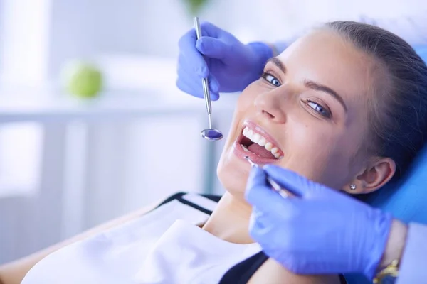 Mujer joven con la boca abierta examinando la inspección dental en el consultorio del dentista. —  Fotos de Stock