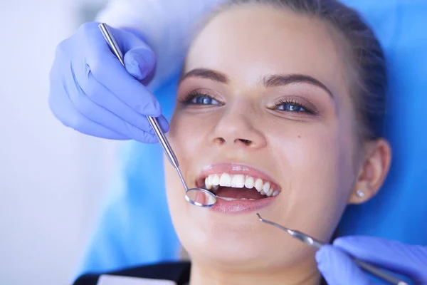 Mujer joven con la boca abierta examinando la inspección dental en el consultorio del dentista. — Foto de Stock