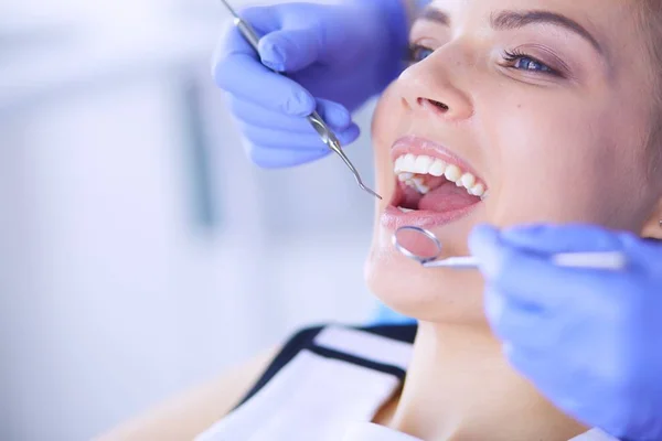 Mujer joven con la boca abierta examinando la inspección dental en el consultorio del dentista. — Foto de Stock