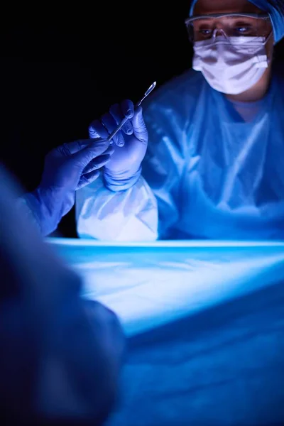 Geschnittenes Bild von Skalpell entnommenen Ärzten, die chirurgische Eingriffe durchführen. — Stockfoto