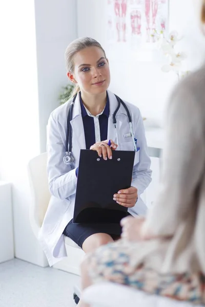 Doctor y paciente discutiendo algo mientras están sentados en la mesa. Concepto de medicina y salud — Foto de Stock