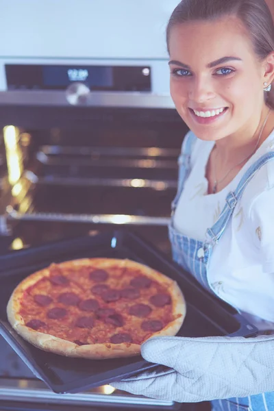 Glückliche junge Frau kocht zu Hause Pizza — Stockfoto