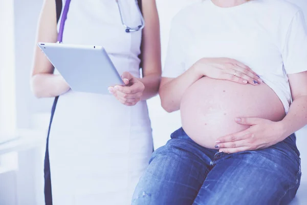 Doctora joven examinando a una mujer embarazada en la clínica. — Foto de Stock