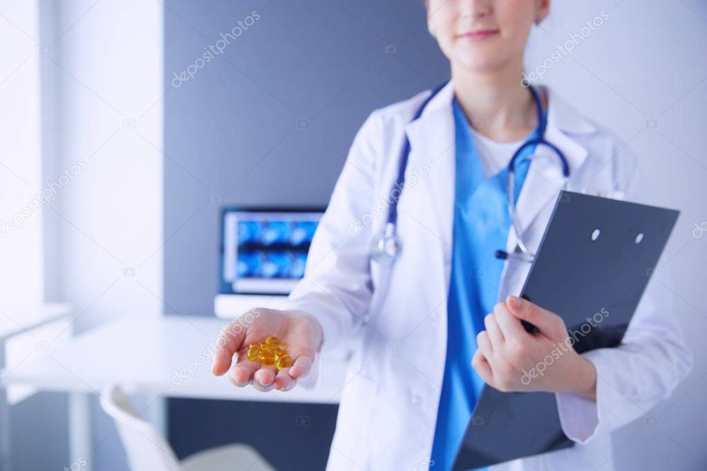 Close-up shot of doctors hands holding pills at clinic.