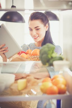 Gülümseyen kadın buzdolabından taze meyve alıyor, sağlıklı yiyecek konsepti.