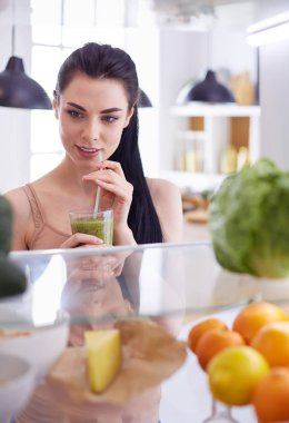 Gülümseyen kadın buzdolabından taze meyve alıyor, sağlıklı yiyecek konsepti.