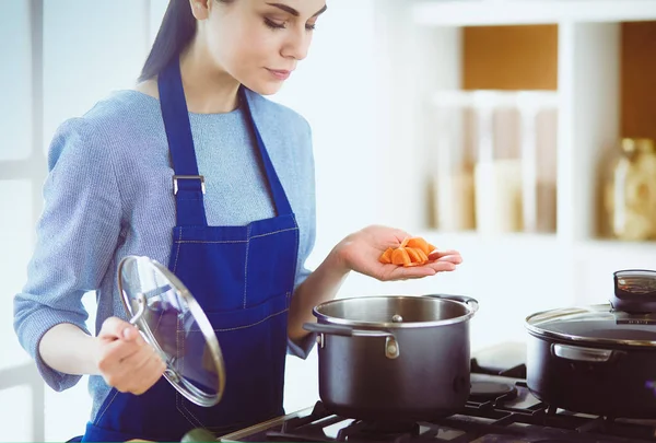 Cozinhar mulher na cozinha com colher de madeira — Fotografia de Stock