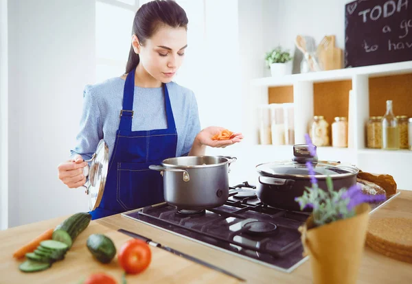 Mujer cocinera en cocina con cuchara de madera — Foto de Stock