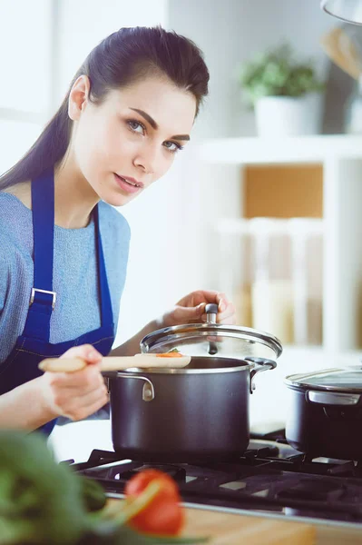 Cooking woman in kitchen with wooden spoon — Stock Photo, Image