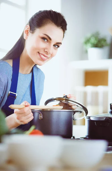 Cozinhar mulher na cozinha com colher de madeira — Fotografia de Stock