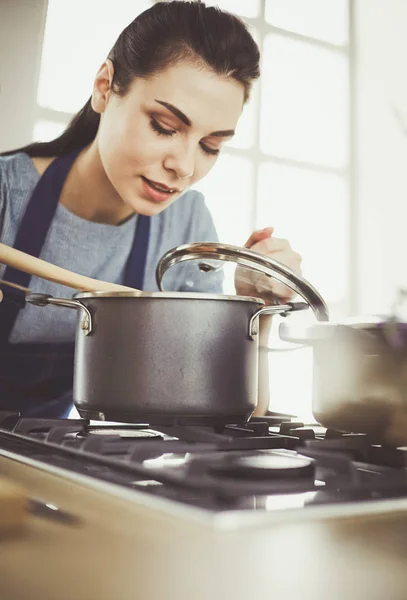 Mujer cocinera en cocina con cuchara de madera — Foto de Stock