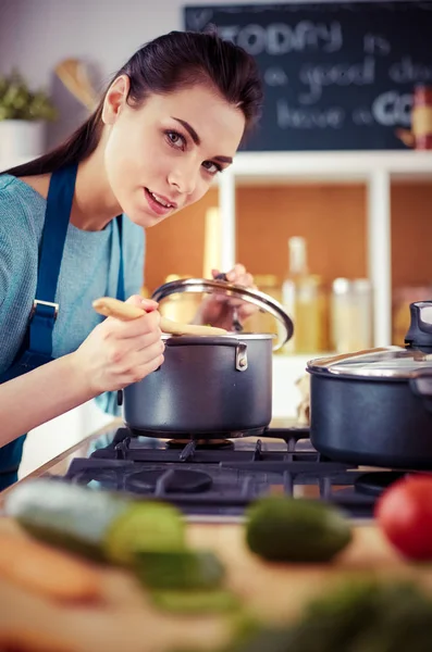 Cozinhar mulher na cozinha com colher de madeira — Fotografia de Stock