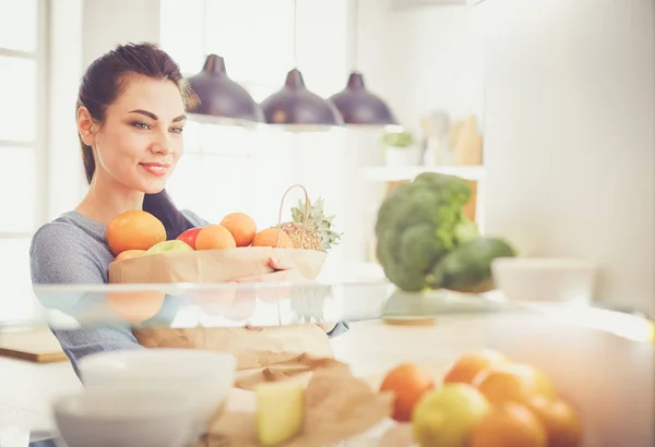 Lächelnde Frau holt frisches Obst aus dem Kühlschrank, gesundes Ernährungskonzept — Stockfoto