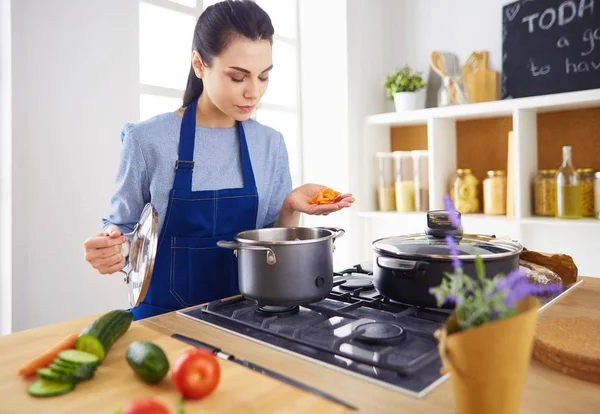 Mujer cocinera en cocina con cuchara de madera — Foto de Stock