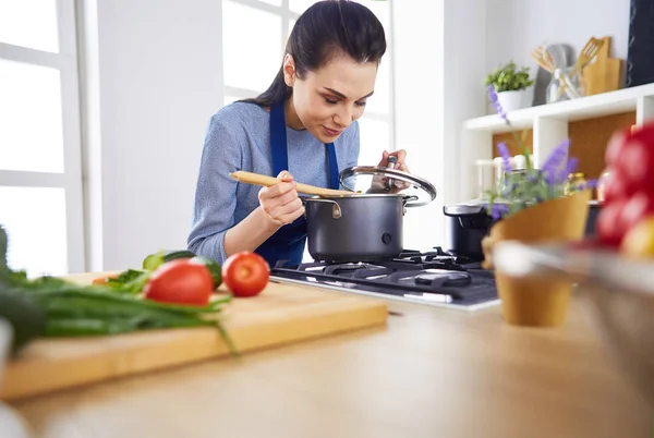 Koken vrouw in keuken met houten lepel — Stockfoto