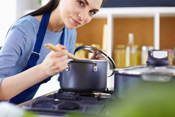 Mujer cocinera en cocina con cuchara de madera — Foto de Stock