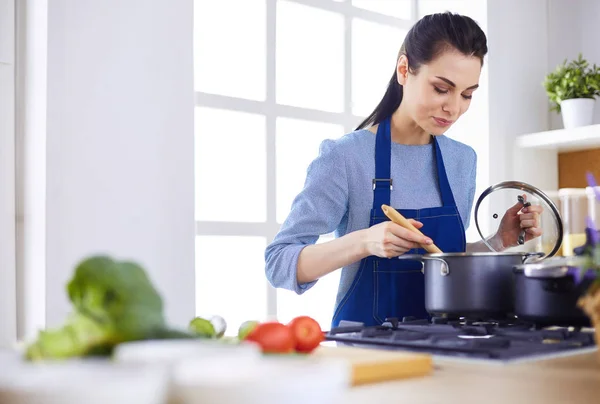 Mujer cocinera en cocina con cuchara de madera — Foto de Stock