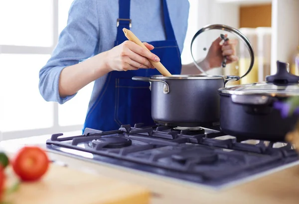 Cooking woman in kitchen with wooden spoon — Stock Photo, Image