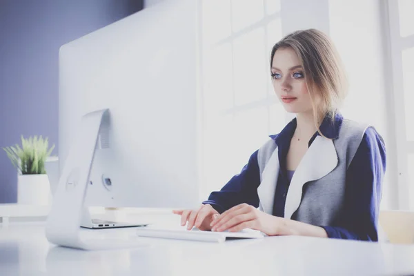 Young confident businesswoman working at office desk and typing with a laptop — Stock Photo, Image