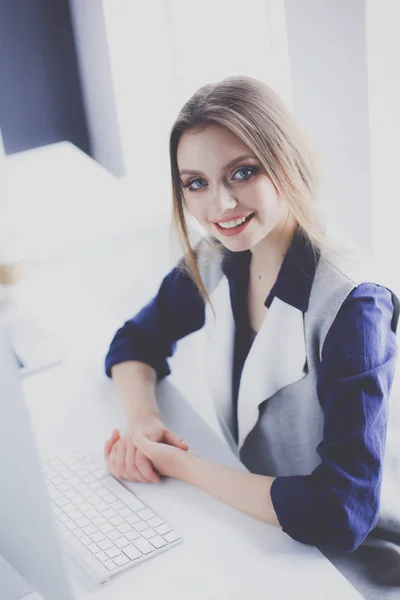 Молода впевнена бізнес-леді, що працює за офісним столом і друкує з ноутбуком — стокове фото
