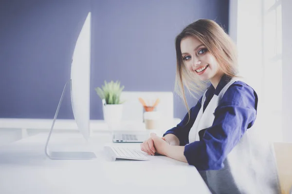 Joven empresaria confiada trabajando en el escritorio de la oficina y escribiendo con una computadora portátil — Foto de Stock