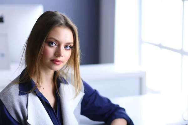 Young confident businesswoman working at office desk and typing with a laptop — Stock Photo, Image