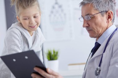 Küçük tatlı bir kız ve hastanedeki doktorunun portresi.