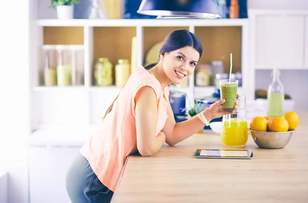 Vacker ung kvinna med hjälp av en digital tablett i köket. — Stockfoto