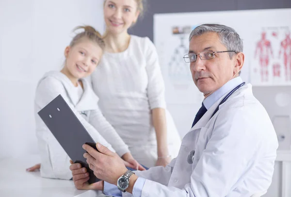 Klein meisje met haar moeder op consult bij een dokter — Stockfoto