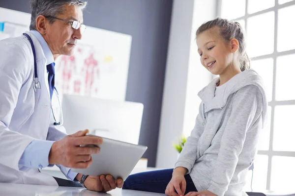 Portrait of a cute little girl and her doctor at hospital — Stock Photo, Image