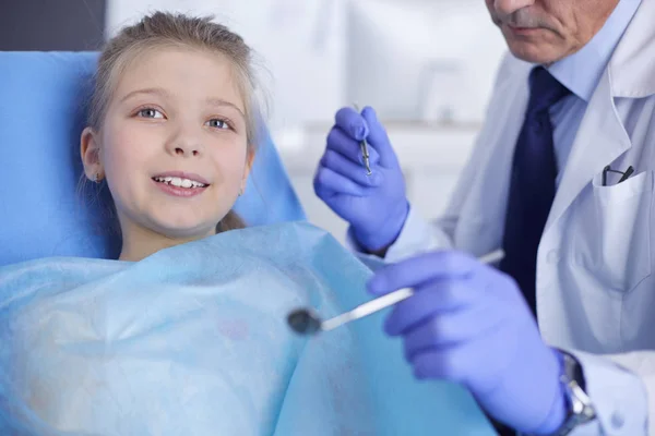 Niña sentada en el consultorio de dentistas — Foto de Stock