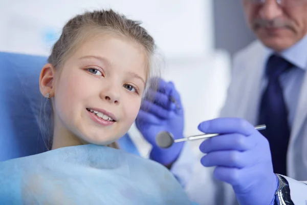 Niña sentada en el consultorio de dentistas — Foto de Stock