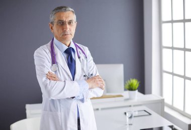 Parlak ofisinde gülümseyen bir doktorun portresi.