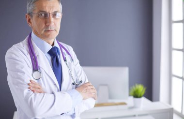 Parlak ofisinde gülümseyen bir doktorun portresi.